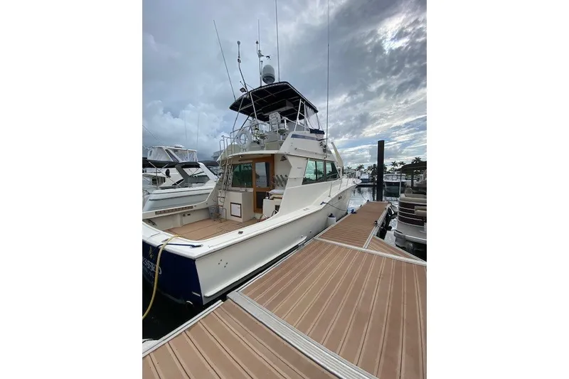Slide: The Image of 1984 Hatteras 46 Convertible yacht docked at marina under cloudy sky. - 17