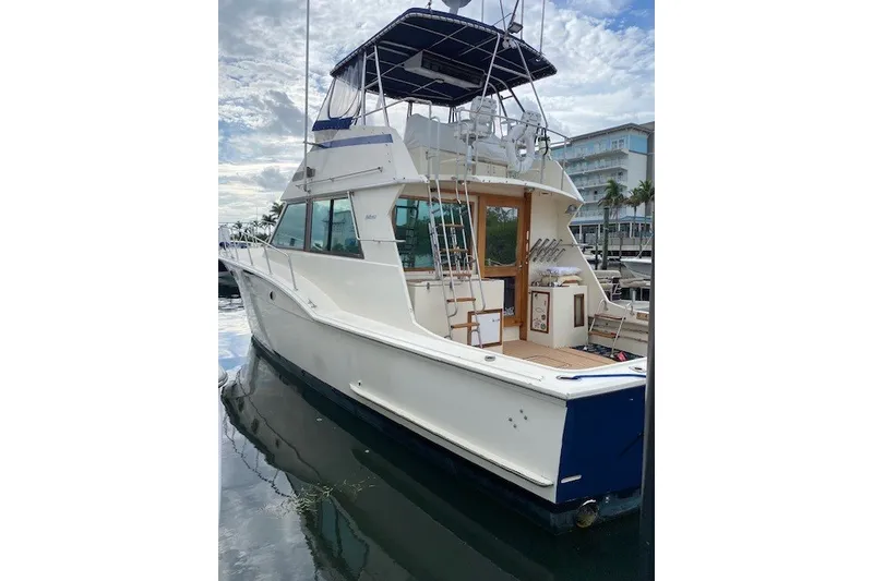 Slide: The Image of 1984 Hatteras 46 Convertible yacht docked, showcasing sleek design and spacious deck. - 16