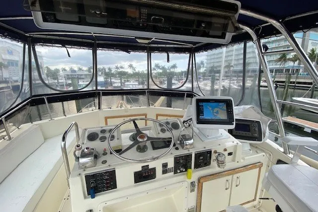 Slide: The Image of Cockpit of 1984 Hatteras 46 Convertible yacht with navigation equipment and marina view. - 34