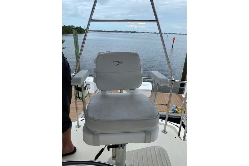 Slide: The Image of Captain's chair on 1984 Hatteras 46 Convertible yacht, overlooking serene waters. - 31