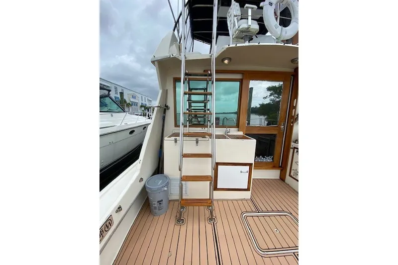 Slide: The Image of 1984 Hatteras 46 Convertible yacht deck with ladder and wooden flooring. - 37