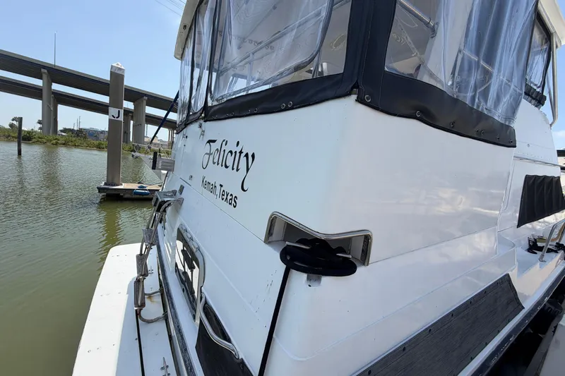 Slide: The Image of 1989 Trojan International 12 Meter Motor Yacht docked with clear windows and name lettering. - 6
