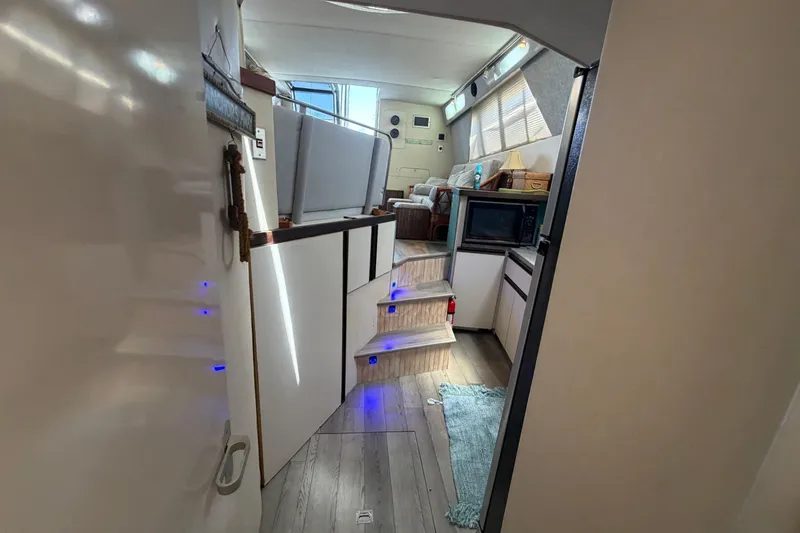 Slide: The Image of Interior view of 1989 Trojan International 12 Meter Motor Yacht, featuring modern kitchen and cozy seating area. - 25