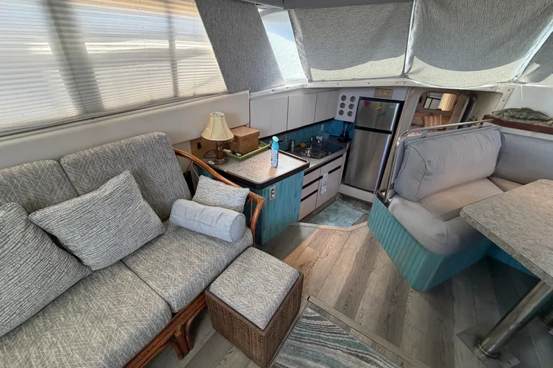 Slide: The Image of Interior of 1989 Trojan International 12 Meter Motor Yacht with cozy seating and kitchen area. - 18