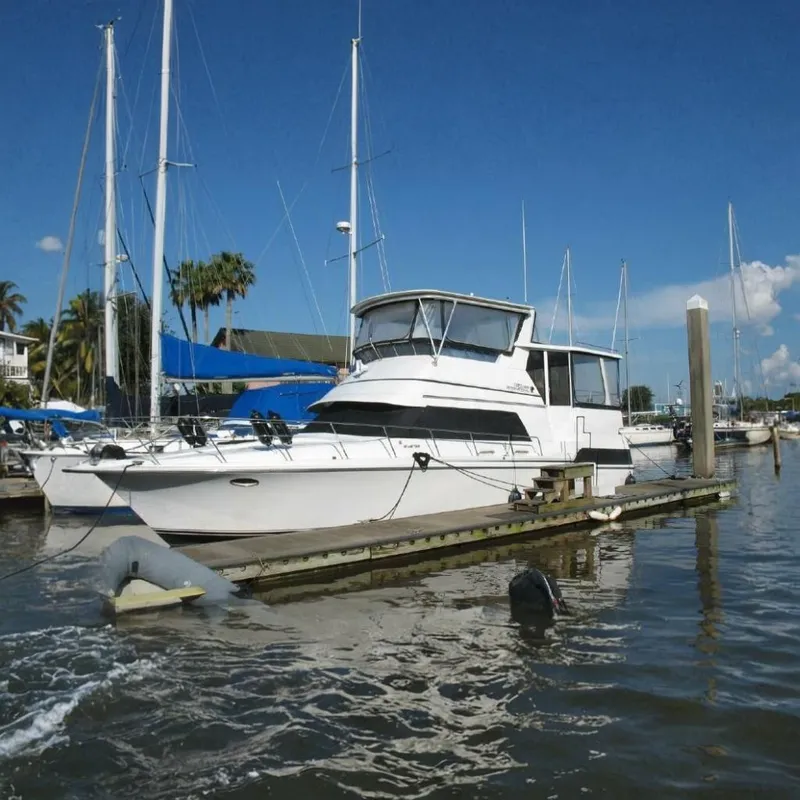 The Image of 1989 Trojan International 12 Meter Motor Yacht docked, surrounded by other sailboats. - 0