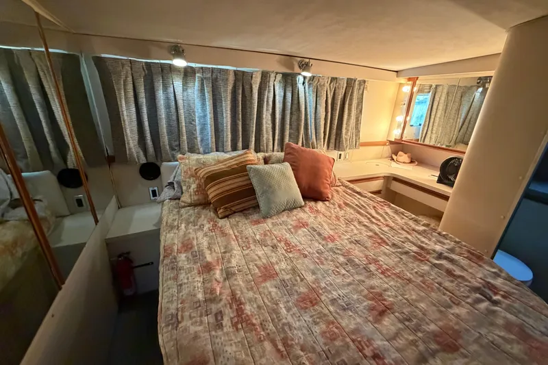 Slide: The Image of Cozy bedroom interior of 1989 Trojan International 12 Meter Motor Yacht with patterned bedding and pillows. - 26