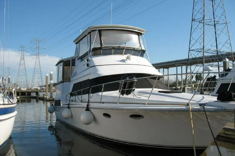 Slide: The Image of 1989 Trojan International 12 Meter Motor Yacht docked at marina under clear blue sky. - 4