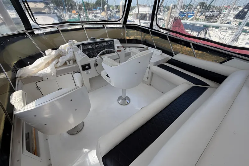 Slide: The Image of Cockpit of 1989 Trojan International 12 Meter Motor Yacht with white seating and control panel. - 9