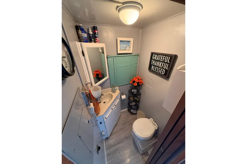 Slide: The Image of Compact RV bathroom with decor, mirror, and storage in a 1997 Fun Country model 56. - 13