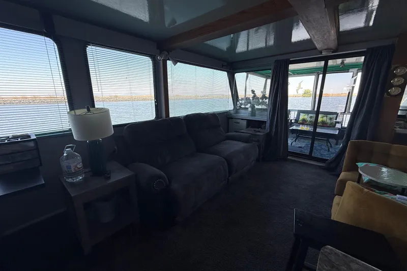 Slide: The Image of Cozy houseboat interior with lake view, featuring a sofa, lamp, and sliding glass doors. - 19