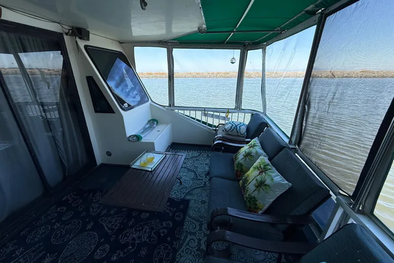 Slide: The Image of Cozy houseboat deck with seating, pillows, and lake view; Fun Country 56, 1997 model. - 10