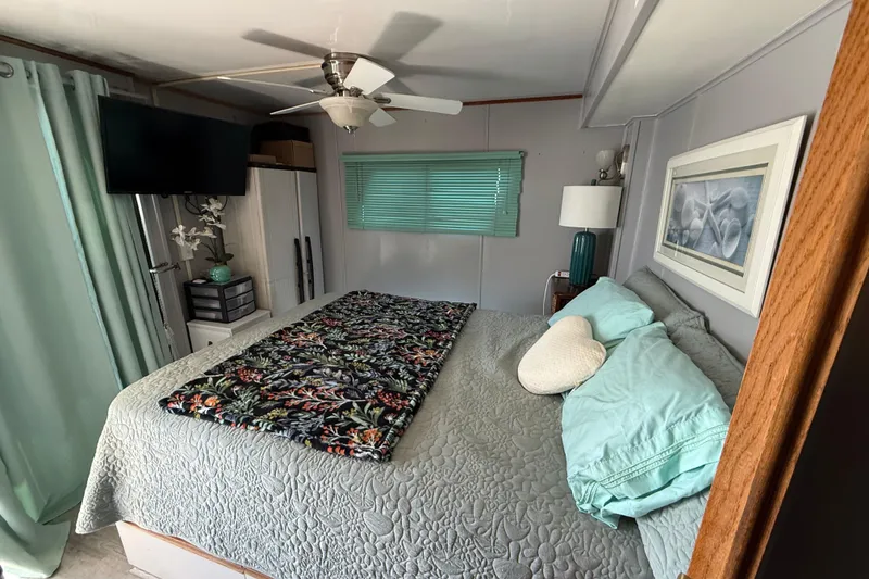 Slide: The Image of Cozy bedroom in 1997 Fun Country model 56 houseboat with floral decor and modern amenities. - 14