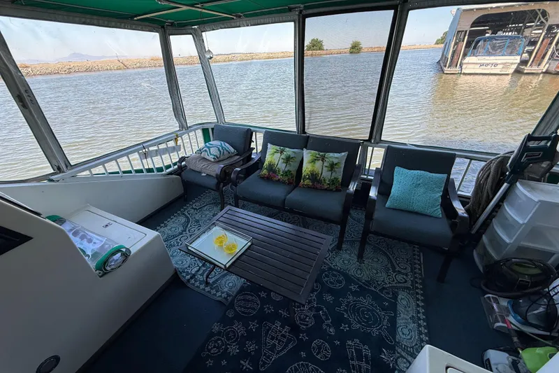 Slide: The Image of Houseboat interior with cozy seating, tropical pillows, and scenic water view, Fun Country 56, 1997 model. - 11
