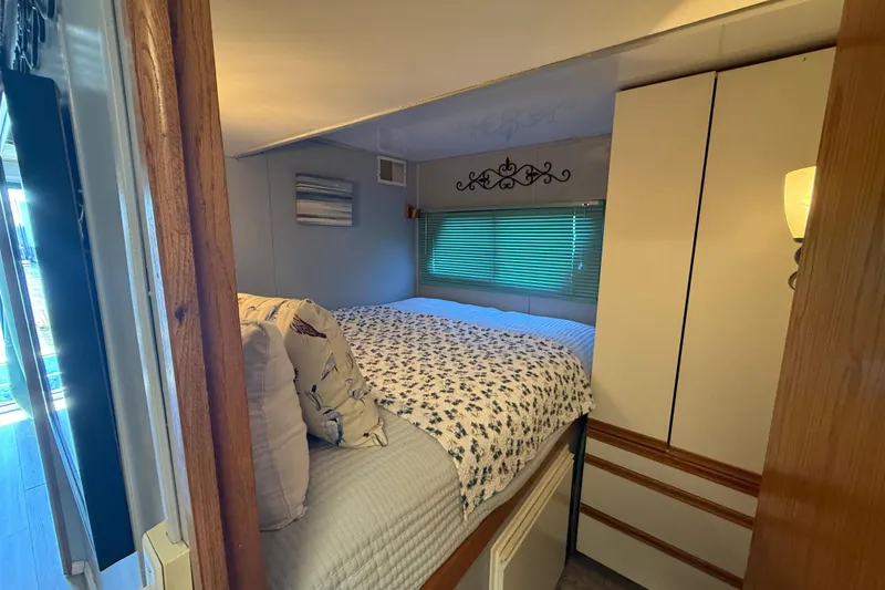 Slide: The Image of Cozy bedroom in 1997 Fun Country model 56 houseboat with floral bedding and decorative wall art. - 15
