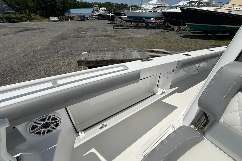 Slide: The Image of 2026 Everglades 253 Center Console boat interior with storage compartment and speaker. - 24