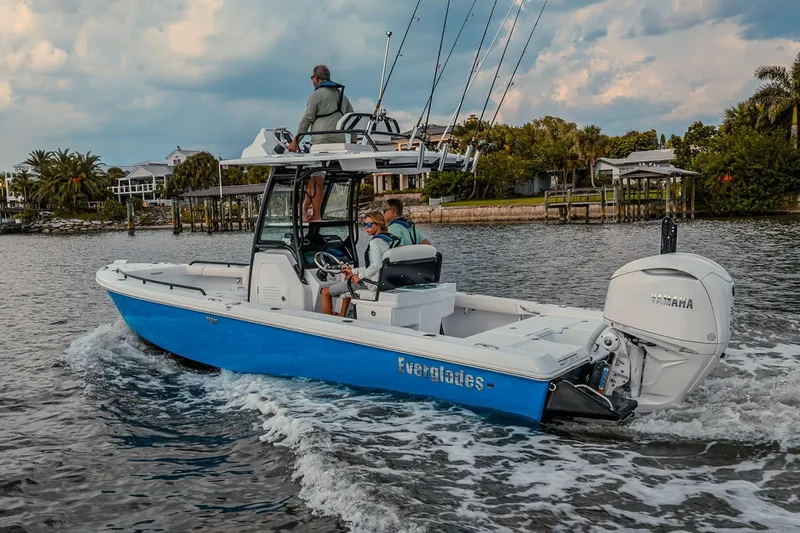 Slide: The Image of Manufacturer Provided Image: 2025 Everglades 253 Center Console boat cruising on a scenic waterway. - 2