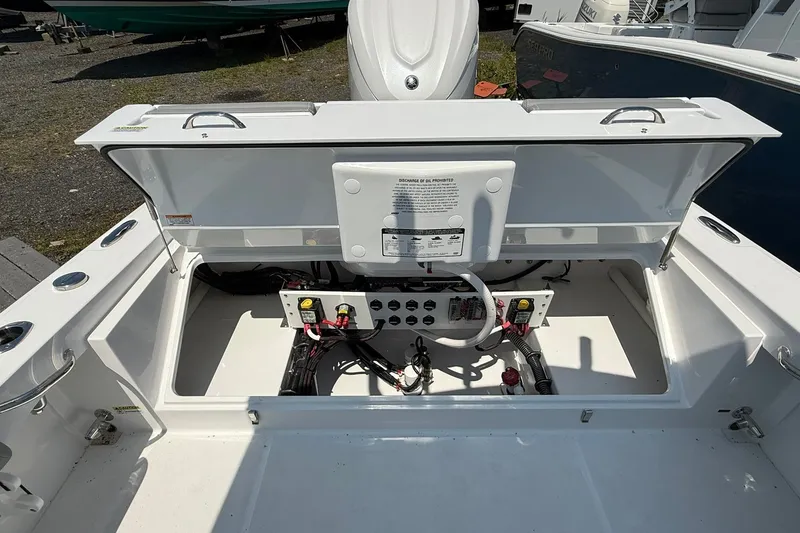 Slide: The Image of Open storage compartment of 2026 Everglades 253 Center Console boat, showcasing wiring and components. - 15