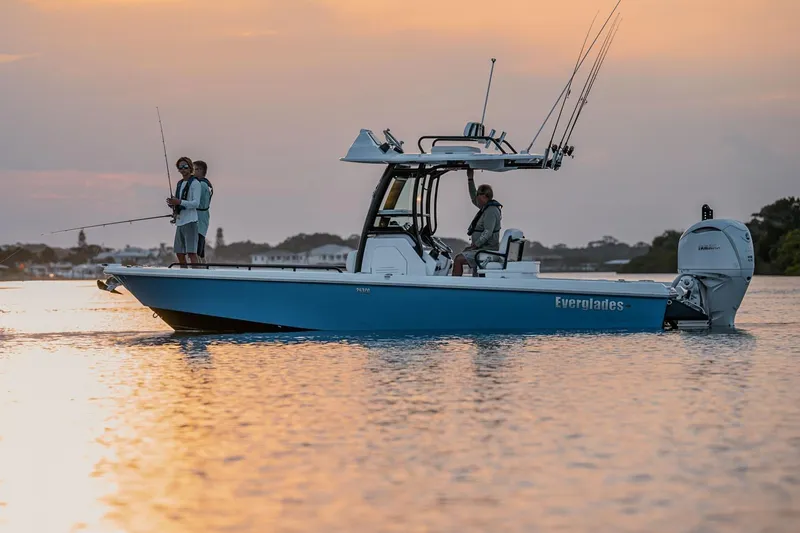 Slide: The Image of Manufacturer Provided Image: 2025 Everglades 253 Center Console boat on water at sunset, with people fishing. - 1