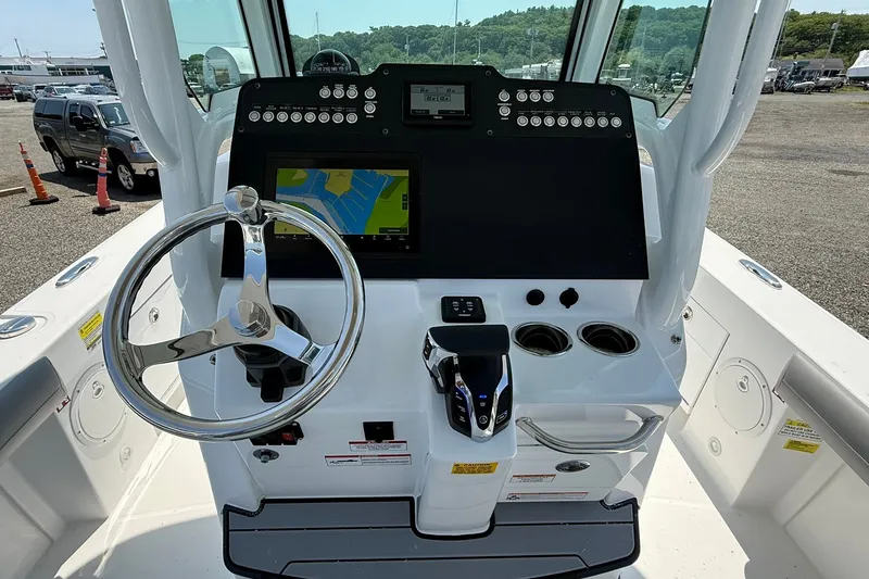Slide: The Image of 2026 Everglades 253 Center Console boat dashboard with steering wheel and navigation display. - 21