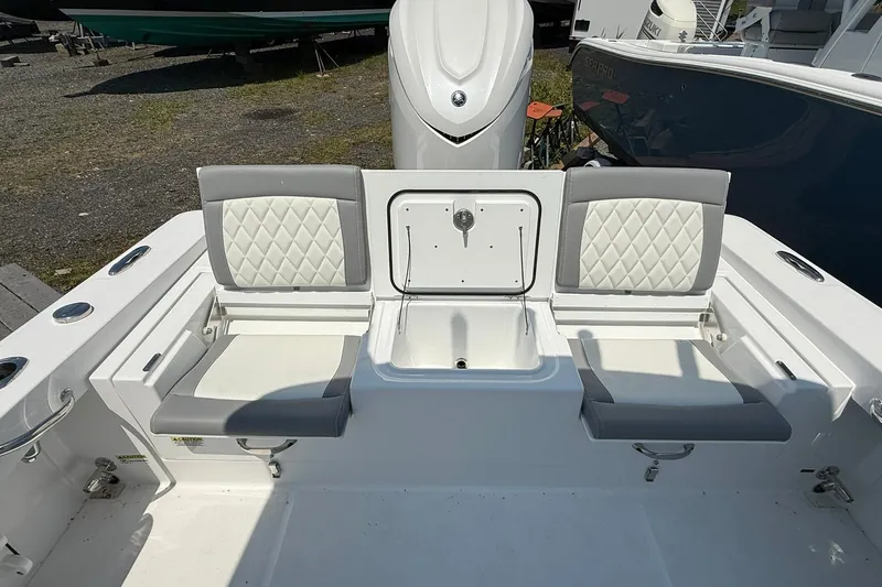 Slide: The Image of 2026 Everglades 253 Center Console boat seating area with storage compartment. - 14