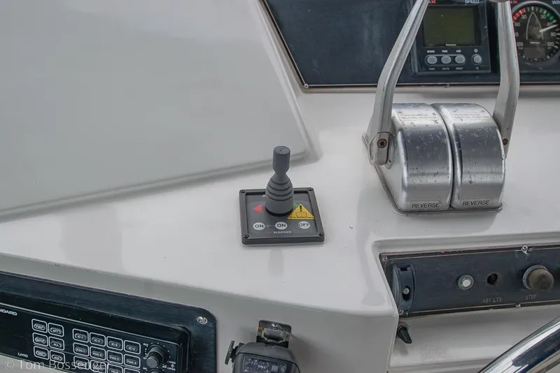 Slide: The Image of Control panel of a 1990 Kha Shing Flush Deck Motor Yacht with throttle levers and joystick. - 48