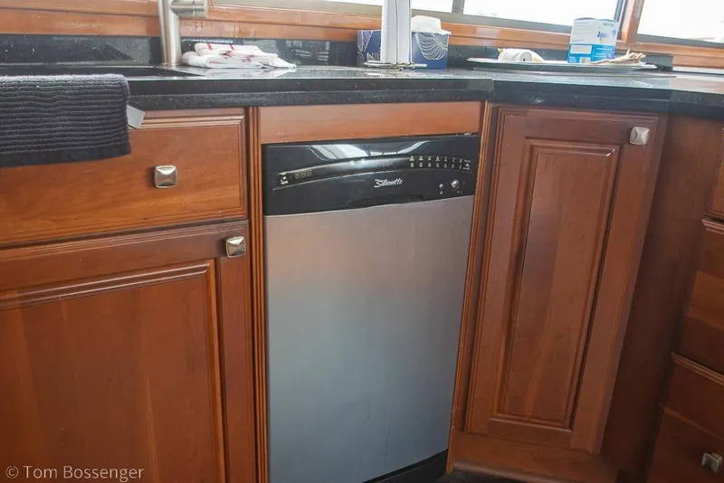 Slide: The Image of Kitchen area of 1990 Kha Shing Flush Deck Motor Yacht with dishwasher and wooden cabinets. - 26