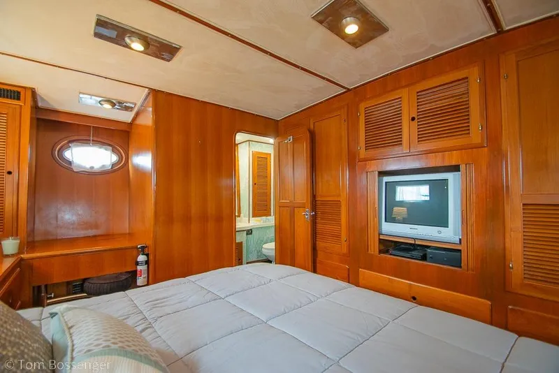 Slide: The Image of Luxurious 1990 Kha Shing Flush Deck Motor Yacht bedroom with wood paneling and TV. - 20