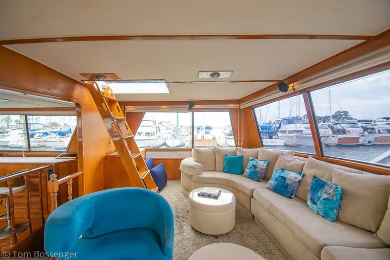 Slide: The Image of Luxurious 1990 Kha Shing Flush Deck Motor Yacht interior with plush seating and marina view. - 12