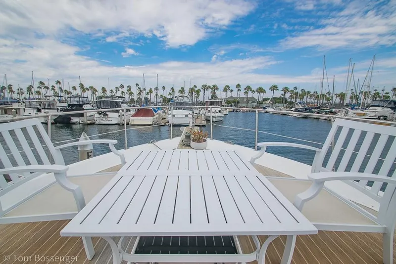 Slide: The Image of White deck furniture on 1990 Kha Shing Flush Deck Motor Yacht, overlooking marina with palm trees. - 57