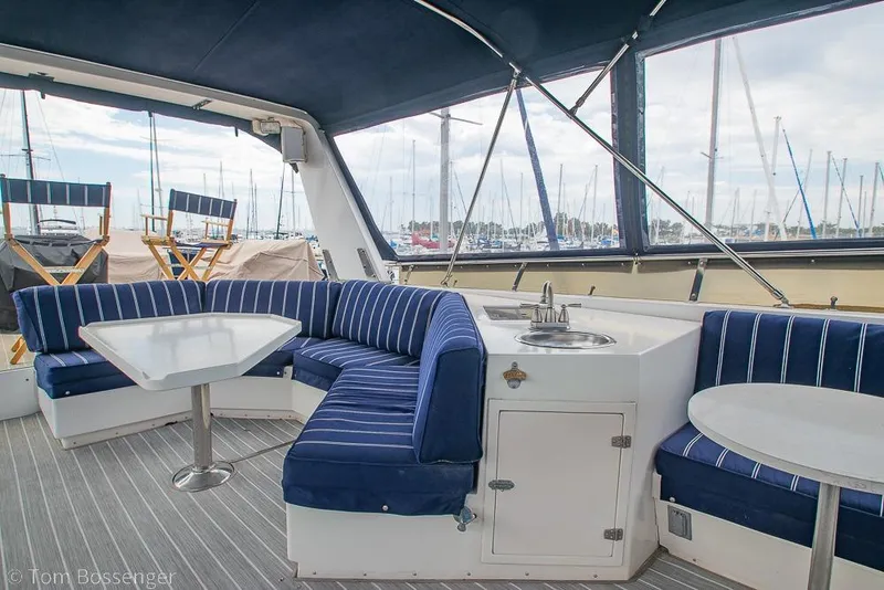 Slide: The Image of Luxurious 1990 Kha Shing Flush Deck Motor Yacht interior with blue-striped seating and tables. - 43