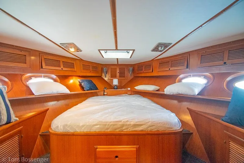 Slide: The Image of Luxurious 1990 Kha Shing Flush Deck Motor Yacht cabin with cozy bed and wooden interior. - 28