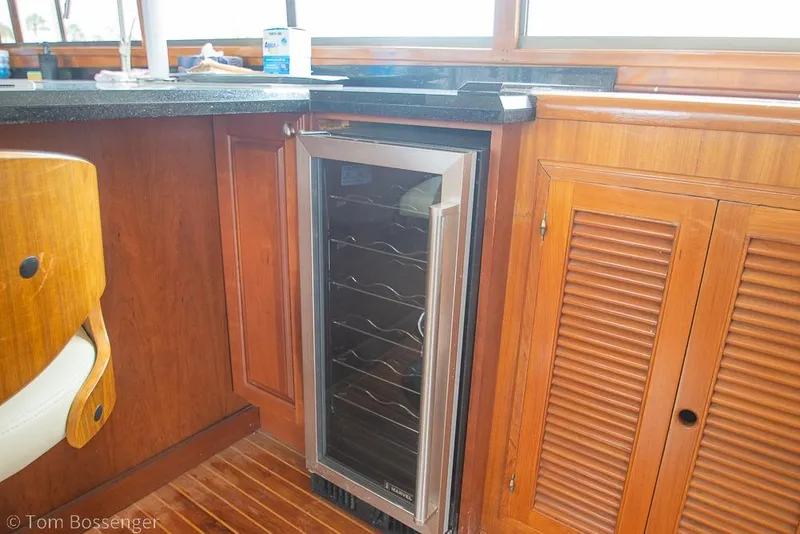 Slide: The Image of Interior of 1990 Kha Shing Flush Deck Motor Yacht with wooden cabinetry and wine cooler. - 7