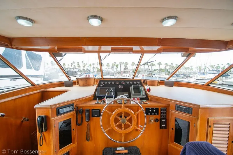 Slide: The Image of 1990 Kha Shing Flush Deck Motor Yacht helm with wooden steering wheel and navigation instruments. - 36