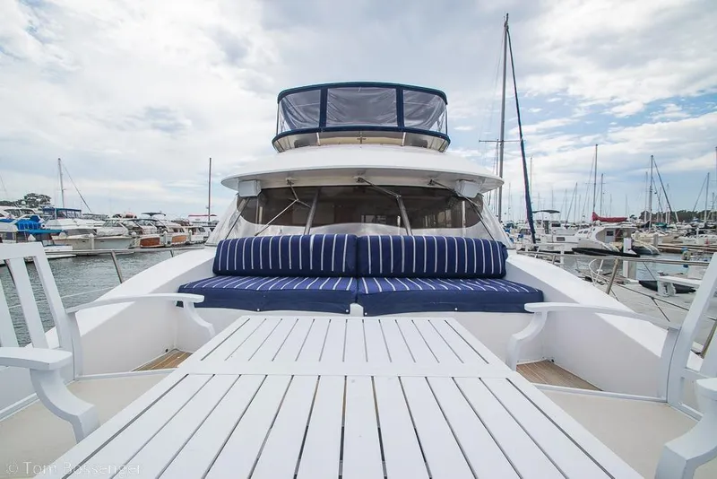Slide: The Image of 1990 Kha Shing Flush Deck Motor Yacht with striped seating at marina. - 56