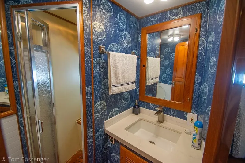 Slide: The Image of Luxurious 1990 Kha Shing Flush Deck Motor Yacht bathroom with elegant blue wallpaper and modern fixtures. - 30