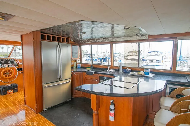 Slide: The Image of Luxurious 1990 Kha Shing Flush Deck Motor Yacht interior with modern kitchen and panoramic windows. - 3