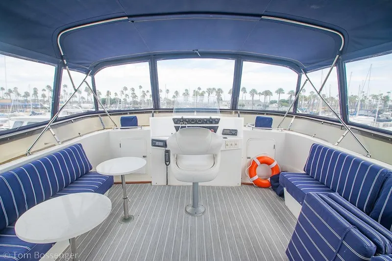 Slide: The Image of 1990 Kha Shing Flush Deck Motor Yacht interior with striped seating and helm view. - 45