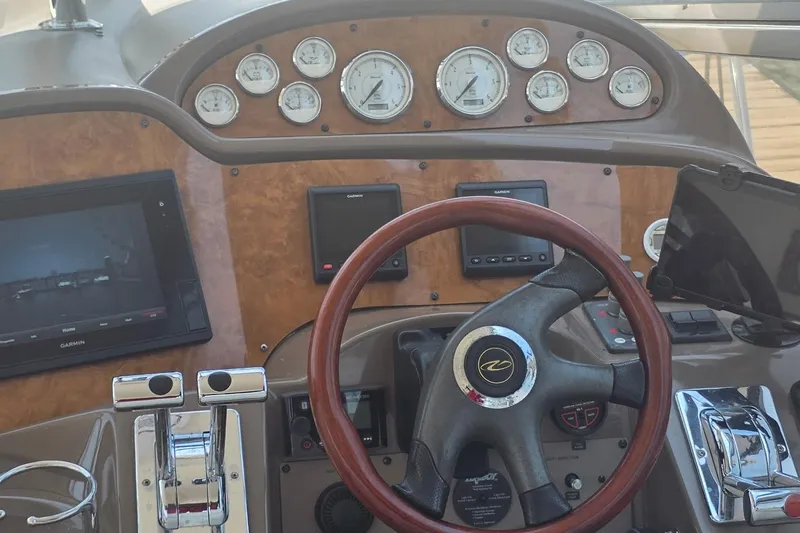 Slide: The Image of Helm of 2005 Regal Commodore 4060 with wood accents and modern navigation instruments. - 23