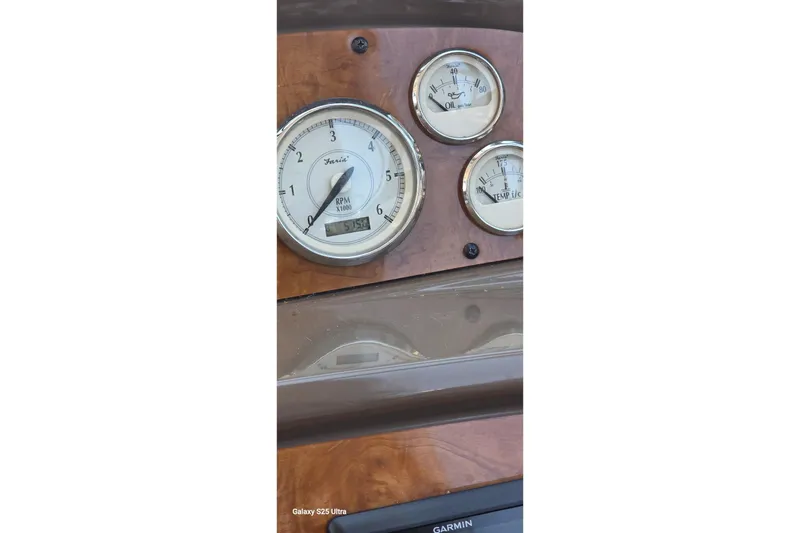 Slide: The Image of Dashboard gauges of a 2005 Regal Commodore 4060 boat, showing RPM, oil, and temperature. - 26
