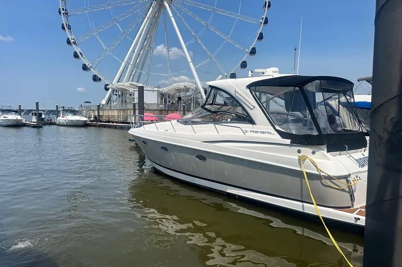 Slide: The Image of 2005 Regal Commodore 4060 yacht docked near a Ferris wheel on a sunny day. - 1