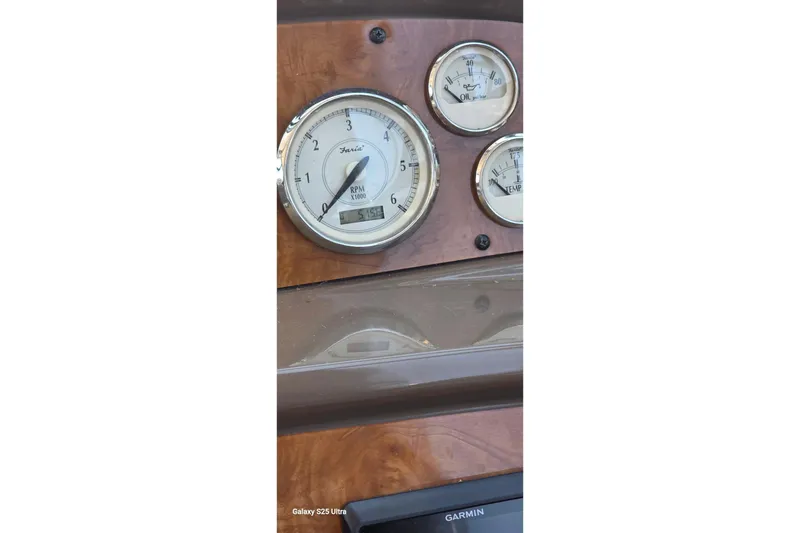 Slide: The Image of Dashboard of a 2005 Regal Commodore 4060 with RPM, oil, and temperature gauges. - 25