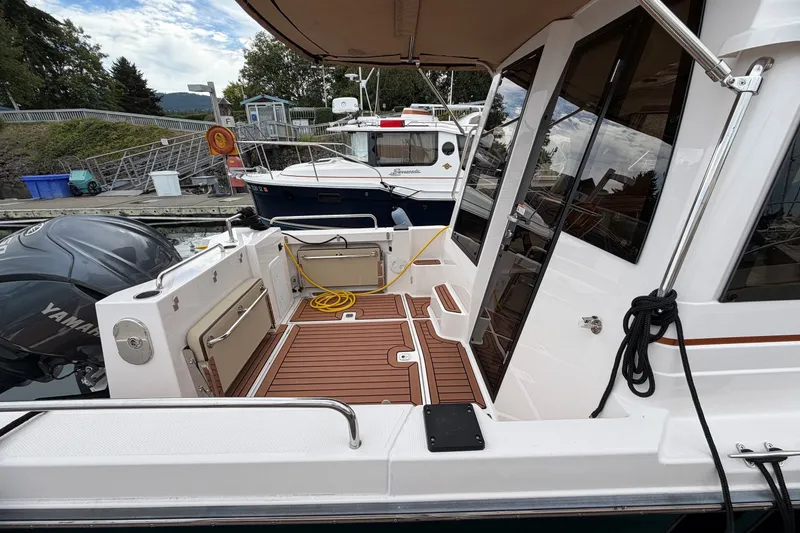 Slide: The Image of 2023 Ranger Tugs R-25 boat deck with Yamaha engine, docked at marina. - 6