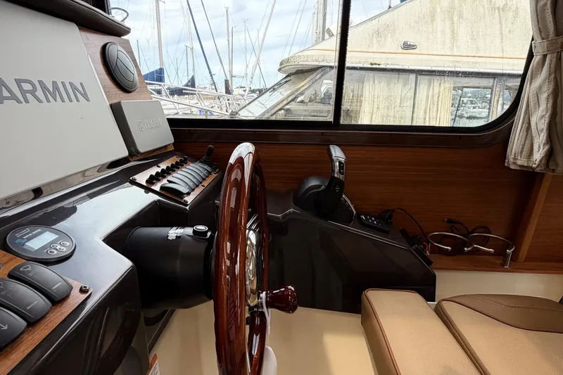 Slide: The Image of Interior of 2023 Ranger Tugs R-25 boat with Garmin navigation system and wooden steering wheel. - 15