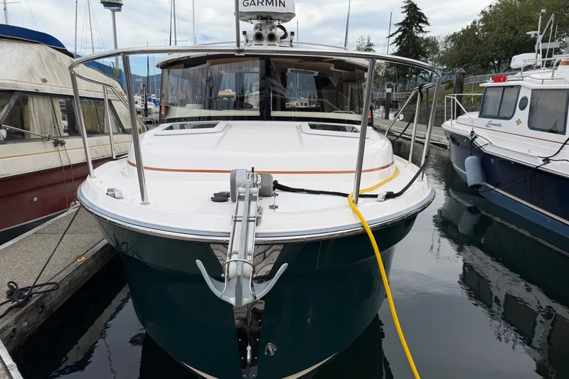 Slide: The Image of 2023 Ranger Tugs R-25 boat docked, featuring a sleek design and Garmin equipment. - 1