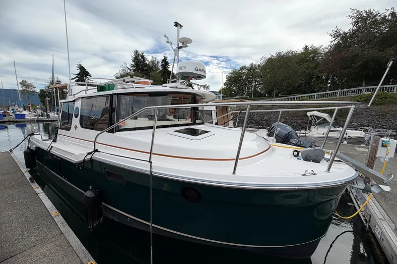 Slide: The Image of 2023 Ranger Tugs R-25 boat docked at marina, featuring sleek design and modern amenities. - 2