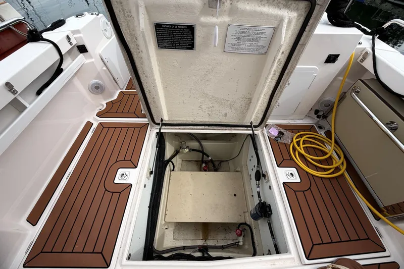 Slide: The Image of Open hatch on 2023 Ranger Tugs R-25 boat deck, revealing storage compartment. - 23