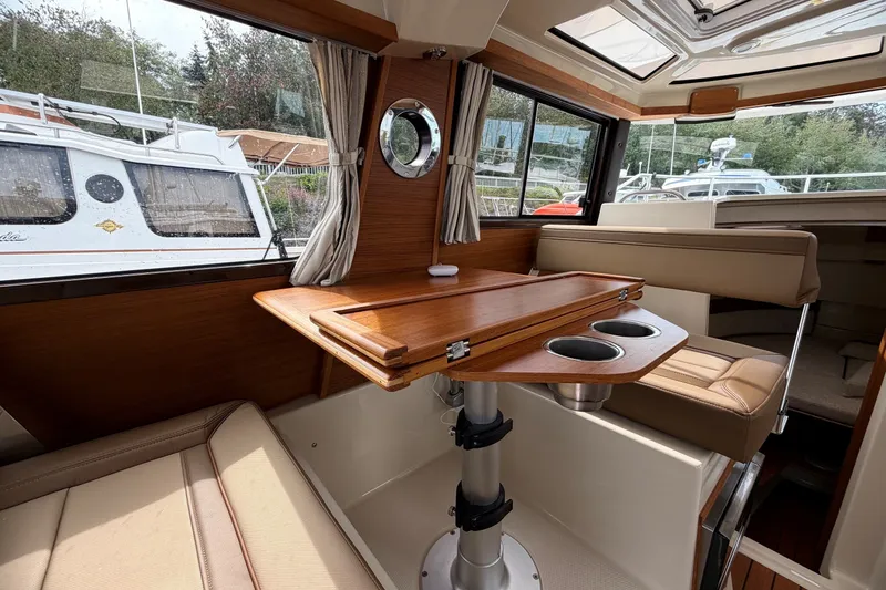 Slide: The Image of Interior of 2023 Ranger Tugs R-25 boat with wooden table and seating area. - 10