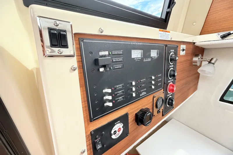 Slide: The Image of Control panel of 2023 Ranger Tugs R-25 boat with switches and gauges. - 21