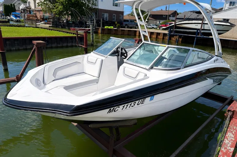 The Image of 2017 Yamaha AR 190 boat docked on a lift in a residential canal. - 1