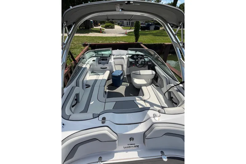 Slide: The Image of 2017 Yamaha AR 190 boat interior with seating and steering wheel, docked by the water. - 3